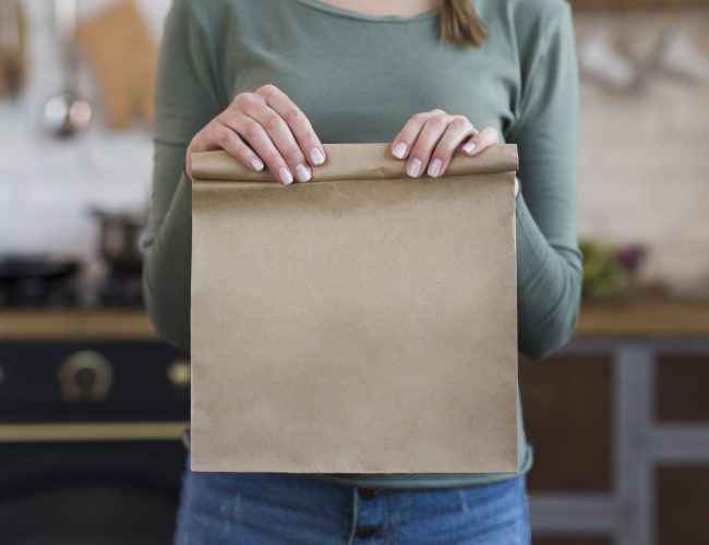 close-up-young-woman-holding-paper-bag